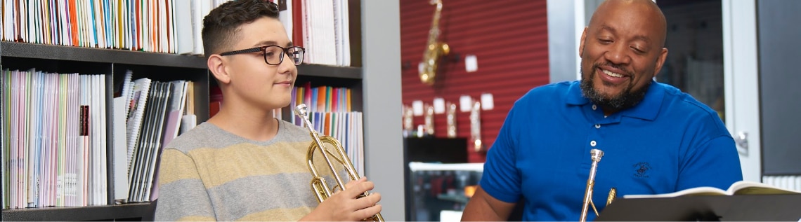 Header image - A music instructor teaching trumpet to a student