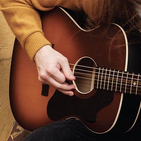 person playing acoustic guitar